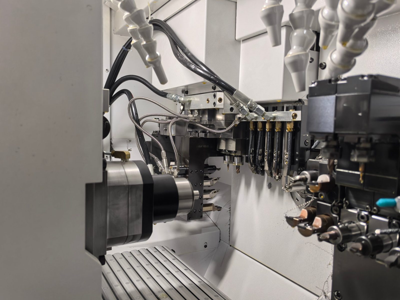 Inside the cutting zone of a Swiss-type lathe — main spindle, guide bush area and live tools